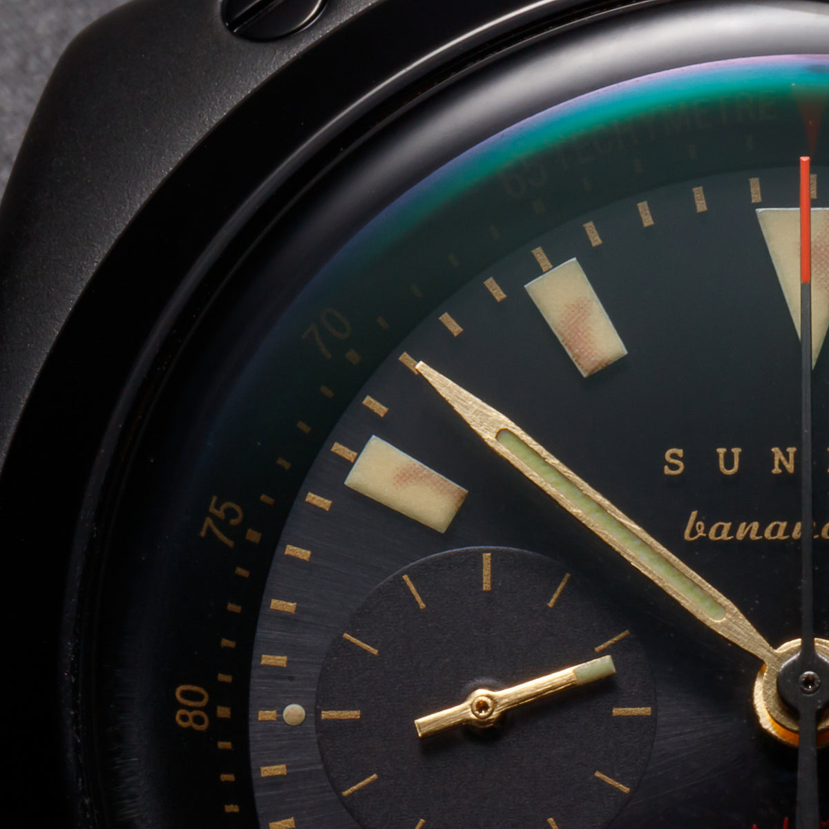 A close view of the black-and-gold chronograph dial.